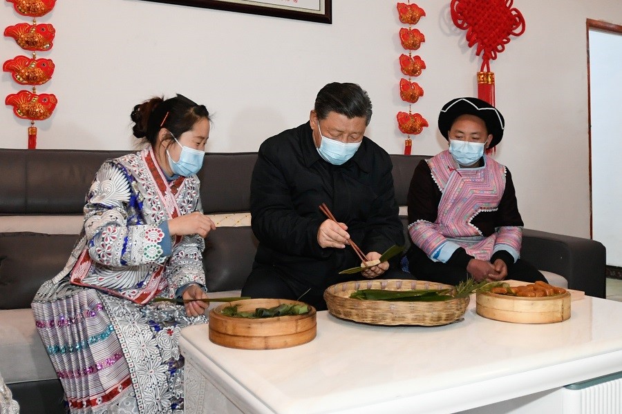 2021年2月3日下午，習(xí)近平在貴州畢節(jié)市黔西縣新仁苗族鄉(xiāng)化屋村苗族村民趙玉學(xué)家，同一家人邊聊家常邊制作當(dāng)?shù)貍鹘y(tǒng)節(jié)日食品黃粑。新華社記者 李學(xué)仁 攝