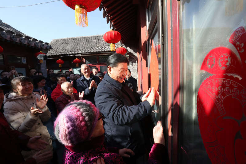 2019年2月1日上午，習(xí)近平在北京前門東區(qū)草廠四條胡同32號院，高興地拿起一幅“?！弊郑H自貼到門上，給這里的老街坊們拜年。新華社記者 鞠鵬 攝
