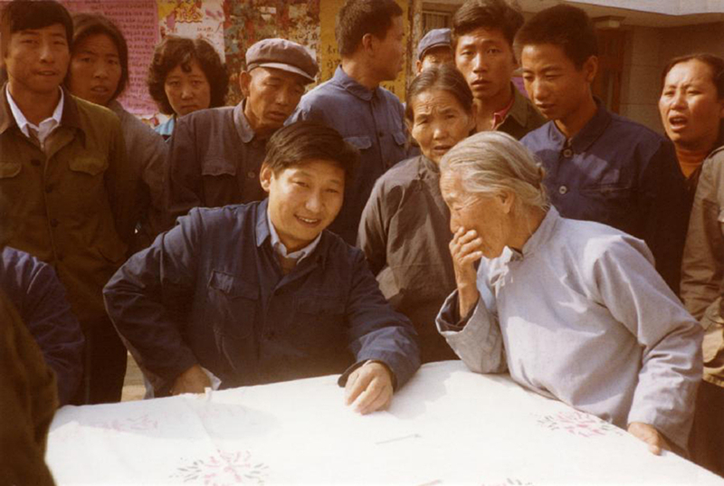 1983年，時(shí)任河北正定縣委書(shū)記的習近平（前排居中），臨時(shí)在大街上擺桌子聽(tīng)取老百姓意見(jiàn)。