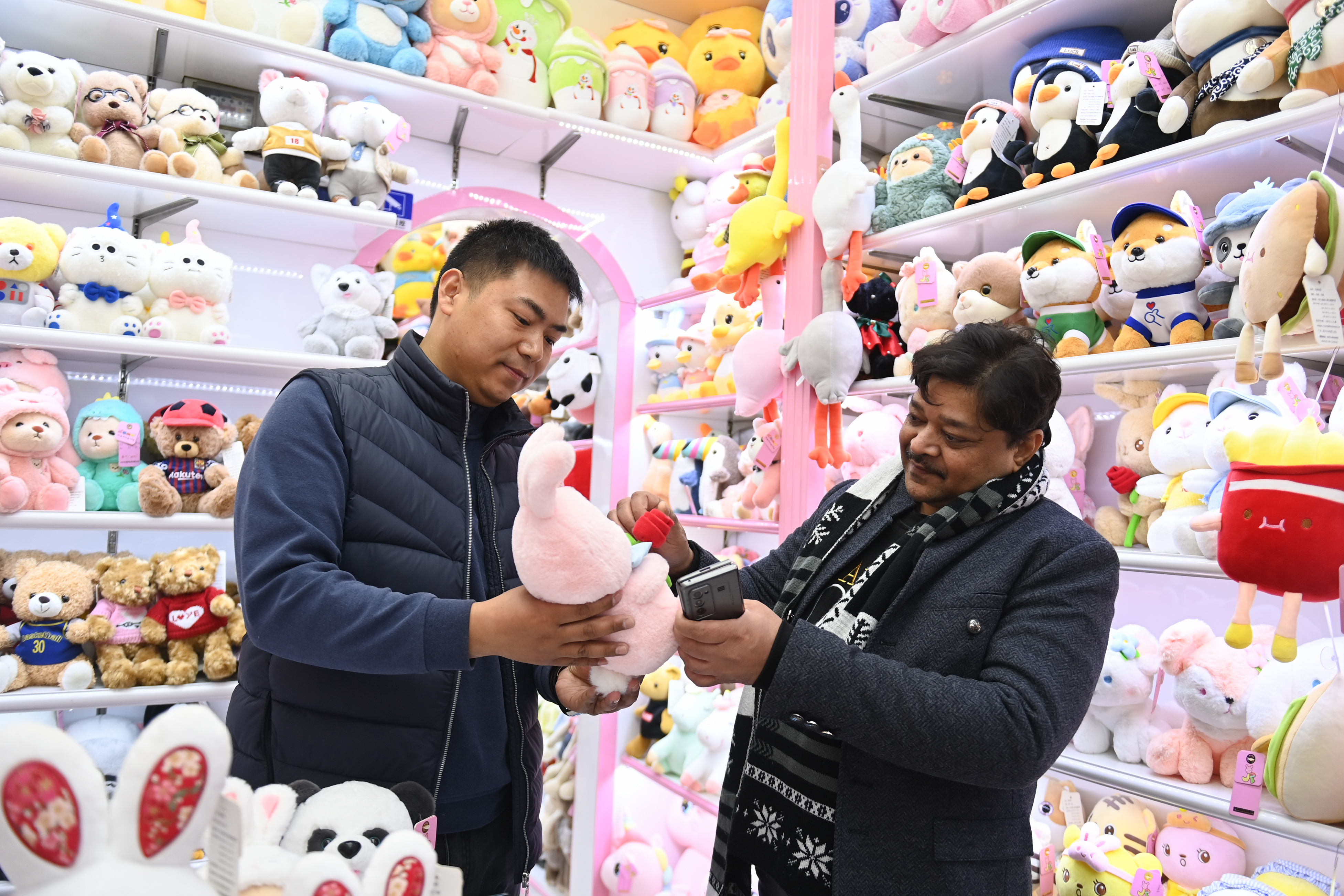 2023年2月2日，來(lái)自印度的客商（右）在義烏國際商貿城的一家玩具店鋪內選購。